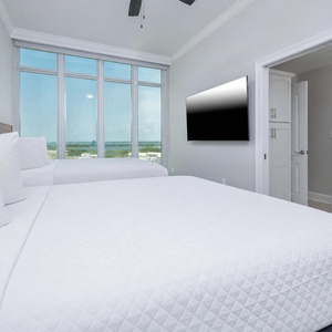 Unwind on the bed as the gulf and shoreline stretch beyond the windows with your favorite show in this queen guest suite