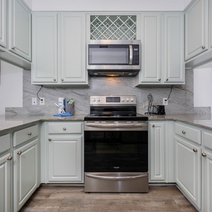 Bright and inviting kitchen featuring stainless appliances and elegant light blue cabinetry, perfect for culinary adventures