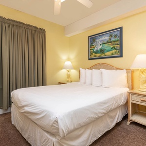 Enjoy restful nights in this guest bedroom with a queen bed, decorative artwork, and soft lighting