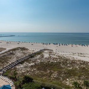 Gaze at the inviting beachfront with colorful umbrellas and a sparkling pool, perfect for relaxation and fun