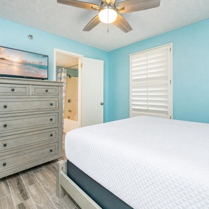 Rest in the guest suite where calming blue walls and a ceiling fan set the tone for peaceful nights