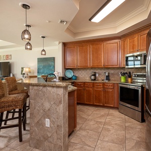 The kitchen features rich wood cabinetry, stainless appliances, and a cozy breakfast bar, perfect for enjoying morning coffee