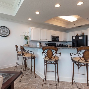 Enjoy meals at the stylish breakfast bar, surrounded by elegant decor and a view into the kitchen