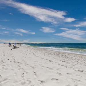 Relax on the soft, white sand while taking in the stunning beachfront view and gentle waves just steps away