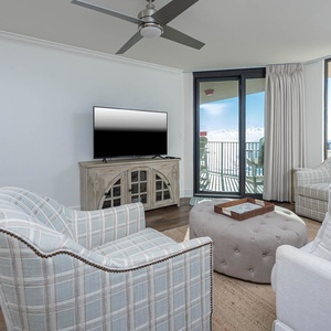 Unwind in the inviting living area with comfortable seating, a TV, and easy access to the balcony for fresh air