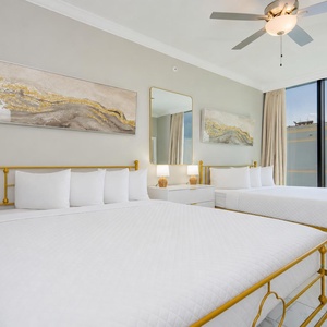 Relax in this guest bedroom featuring two queen beds, soft bedding, and large windows with stunning views