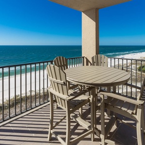 Savor meals at the round table while enjoying expansive views of the water and beach from your balcony