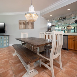 Gather around the dining table for games or conversations, complemented by the soft glow of the elegant chandelier