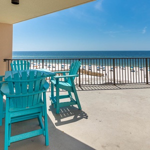 Relax on the turquoise chairs of this balcony while enjoying the breathtaking beach view and gentle sea breeze