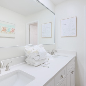 Indulge in self-care amid plush towels and serene decor in the master bath, as you prepare for a day of beach adventures