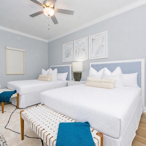 Inviting guest bedroom featuring two queen beds, stylish decor, and natural light that creates a coastal vibe