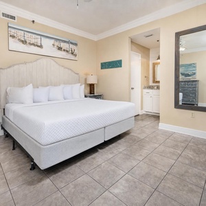 Master bedroom featuring a king bed, coastal decor, and a convenient en-suite bathroom with a stylish mirror