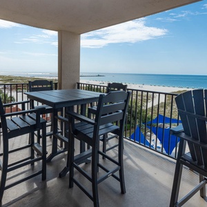 Enjoy meals at the outdoor dining set, with views of the beach and gentle waves in the distance