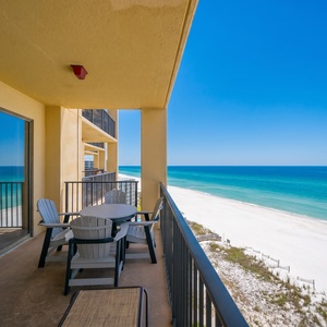 Breathtaking beachfront view showcasing white sand, colorful umbrellas, and calm waters stretching to the horizon