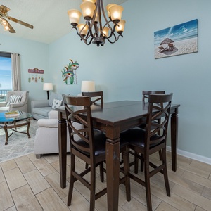 Enjoy meals at the stylish dining table, surrounded by beach-themed decor and natural light from the balcony