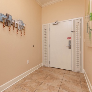 This welcoming entryway features a decorative coat rack and warm beige tones, setting a friendly tone for your stay