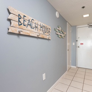 Step into a welcoming entryway adorned with beach decor and a bright, open atmosphere