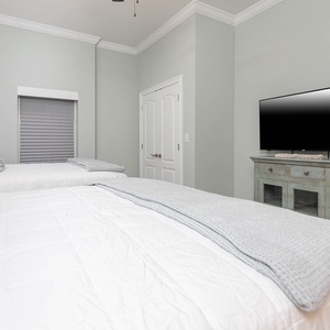Drift off on comfortable queen beds beneath a high ceiling while watching a wall TV for late-night shows