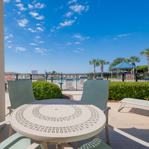 Relax on the outdoor patio overlooking the pool beach area with lush landscaping for a refreshing getaway