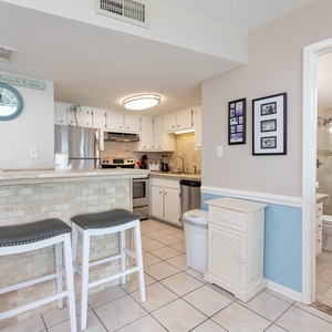 The kitchen features sleek stainless appliances, a stylish breakfast bar, and easy access to a modern bathroom
