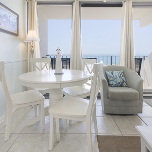 Enjoy a bright dining area with a round table and a cozy chair, offering stunning views of the beachfront