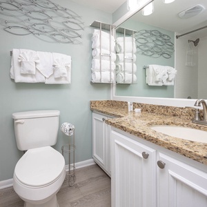 Refresh in the stylish guest bathroom featuring a granite countertop, elegant decor, and ample fluffy towels