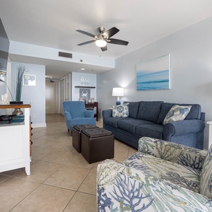 Relax in this living room featuring a cozy blue sofa with queen sleeper, an ottoman, twin trundle, and large mounted TV