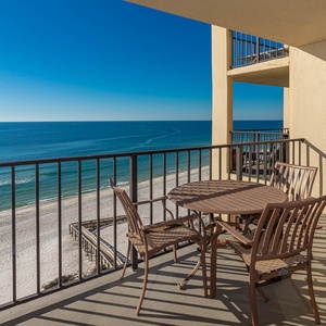 Relax on the private balcony with inviting seating and breathtaking views of the tranquil waters and sandy shore