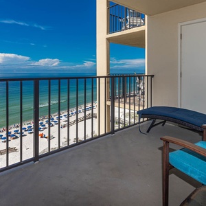 Relax on the private balcony with comfortable seating and breathtaking views of the serene beach and sparkling waters