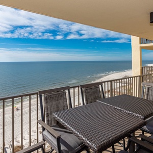 Balcony dining set with views of the tranquil water and white sand, perfect for relaxing moments
