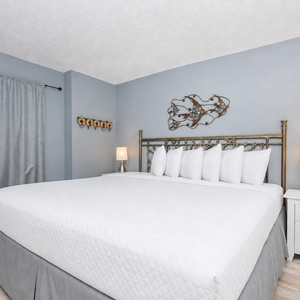 Retreat to this elegant king suite with fluffy pillows, soft gray walls, and a stylish lamp for a relaxing stay