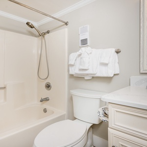 Bright and inviting guest bath featuring a tub/shower combo, plush towels, and a stylish mirror for a refreshing retreat