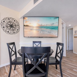 Gather around the black dining table to enjoy your favorite show on the large wall-mounted TV in the dining area