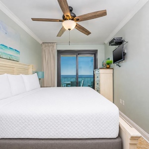 Unwind in the master bedroom featuring a king bed, coastal artwork, and beachfront balcony access