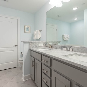 Refresh in the master bath after a day at the beach with a soothing tub and relaxing walk-in shower