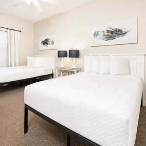 In the guest suite with double beds, you unwind surrounded by peaceful feather artwork and gentle lamp glow