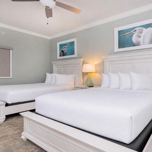Relax in this guest bedroom featuring two queen beds, soft linens, and coastal artwork for a relaxing stay
