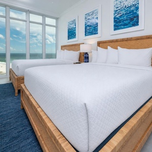 Wake to a breathtaking sunrise in this queen guest suite with two cozy beds and expansive views from the windows