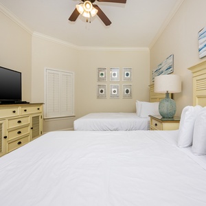 This guest bedroom features two comfortable full beds, a flat-screen TV, and coastal-inspired decor for a relaxing stay