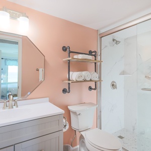 The bathroom features a stylish design with a spacious shower, elegant fixtures, and neatly arranged towels for your comfort
