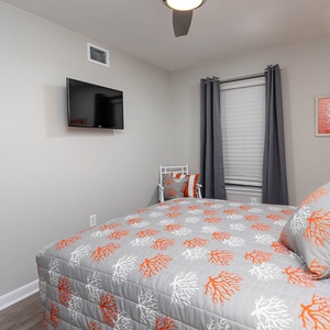 Relax in this inviting guest bedroom featuring a queen bed and a wall-mounted TV