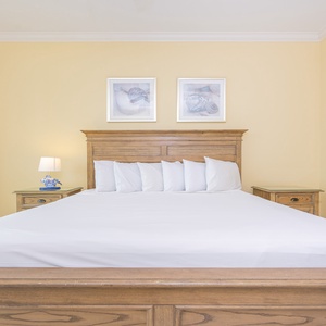 Inviting master bedroom featuring a cozy king-sized bed with plush pillows and soft yellow walls for a relaxing retreat