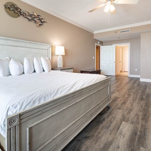 Serene master bedroom featuring a king bed, sofa with queen sleeper, stylish decor, and access to the beach balcony
