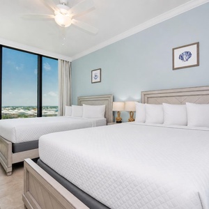 Find relaxation in this guest bedroom with two queens, fluffy pillows, coastal decor and stunning views