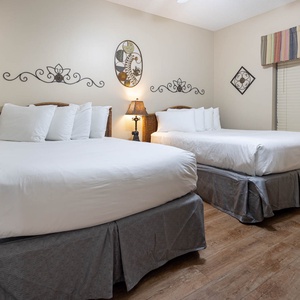 Inviting guest bedroom with two comfortable double beds, tasteful decor, and warm lighting for a restful stay