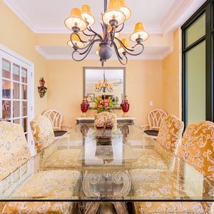 Enjoy delightful gatherings at the elegant dining table, surrounded by vibrant decor and coastal views