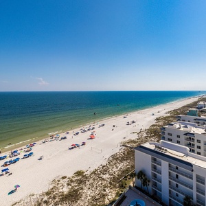 Relax on your balcony and observe the gulf framing the beachfront with colorful umbrellas below