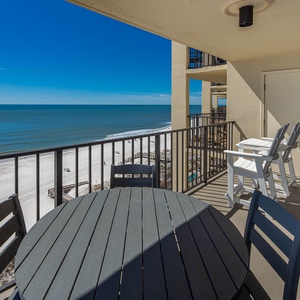Enjoy breathtaking views from the balcony featuring a round table and chairs, perfect for relaxing by the beach