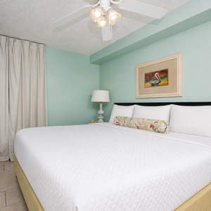 Relax in this serene bedroom featuring a spacious king bed, soft linens, and a flat-screen TV for your entertainment
