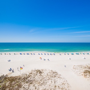 This stunning view showcases a beautiful beach with soft white sand and gentle waves, perfect for a relaxing getaway